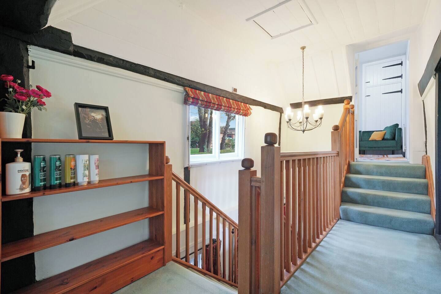 A staircase with wooden railings leading to a room with a green sofa.