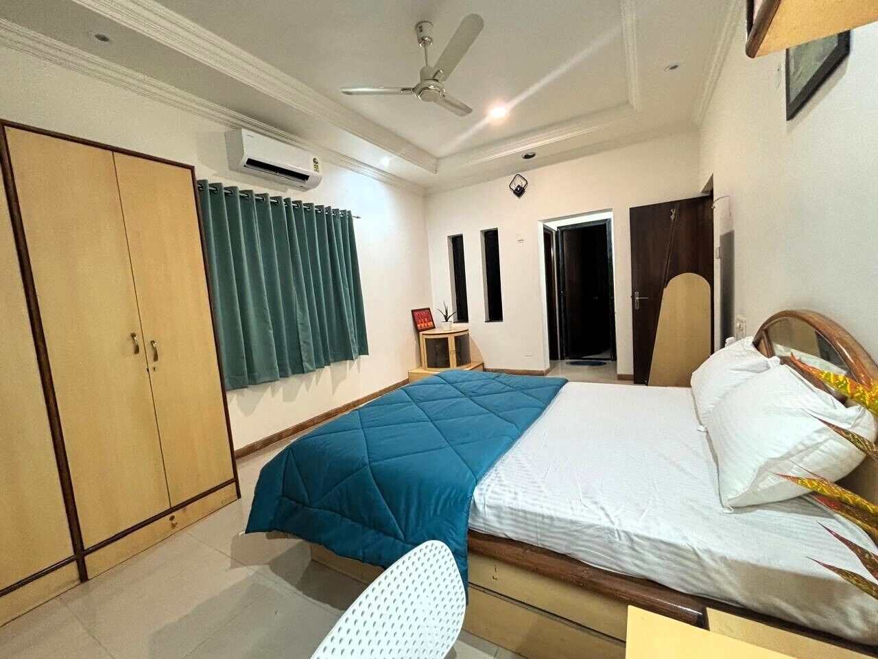 Un dormitorio con cama, armario, escritorio y silla.
