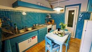 Una cocina con armarios azules, una mesa blanca y un fregadero.