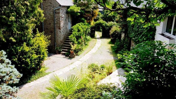 Un edificio de piedra con un camino de grava que conduce a una escalera.