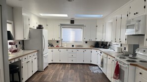 A modern kitchen with white cabinets, a built-in oven, and a skylight. - Century Farm in Horse Heaven Hills, Tri-Cities WA (Kennewick)