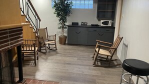 A modern kitchen with a microwave, a potted plant, and a dining area with wooden chairs and a black stool. - Century Farm in Horse Heaven Hills, Tri-Cities WA (Kennewick)