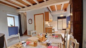 A dining area with a table set for breakfast, including croissants and coffee. - Gîte 4 persons Plestin-les-Grèves (Plestin-les-Grèves)