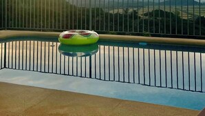 Ein Pool mit Blick auf einen Sonnenuntergang und ferne Berge.