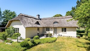 A house with a thatched roof, a brick exterior, and a well-maintained lawn. - "Fausta" - 2km from the sea by Interhome (Gedser)
