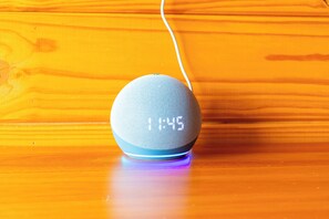 A smart speaker on a wooden surface with a white cable. - Luxury Chalet Plato dos Ventos (Urubici)