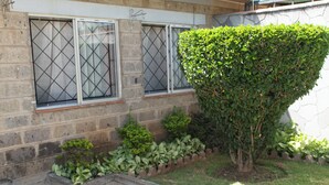 A building with two windows, a hedge, and a small garden area. - LA FONT HOUSE Near JKIA Nairobi (Nairobi)
