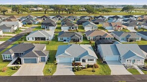 Zona residencial con varias casas, cada una con garaje, entrada para vehículos y césped.