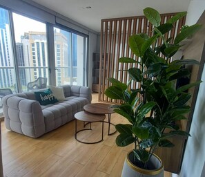 Ein Wohnzimmer mit einer Couch, einem Couchtisch und einer Zimmerpflanze.