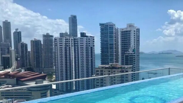 A high-rise building with a pool in the foreground. - Modern Skyline Apartment in Marbella | Pool, Gym, and a Short Walk to the Cinta Costera (Panamá)