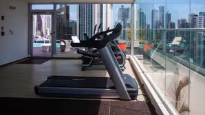 A modern gym with treadmills and a city view. - Modern Skyline Apartment in Marbella | Pool, Gym, and a Short Walk to the Cinta Costera (Panamá)