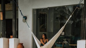 A hammock by a pool with a view of a modern building. - Beachfront Luxury Villa in Playa Venao (Los Santos Province)
