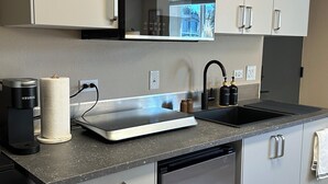 A modern kitchen with a built-in dishwasher, a coffee maker, and a sink. - Private Ptarmigan Suite (Hayden)