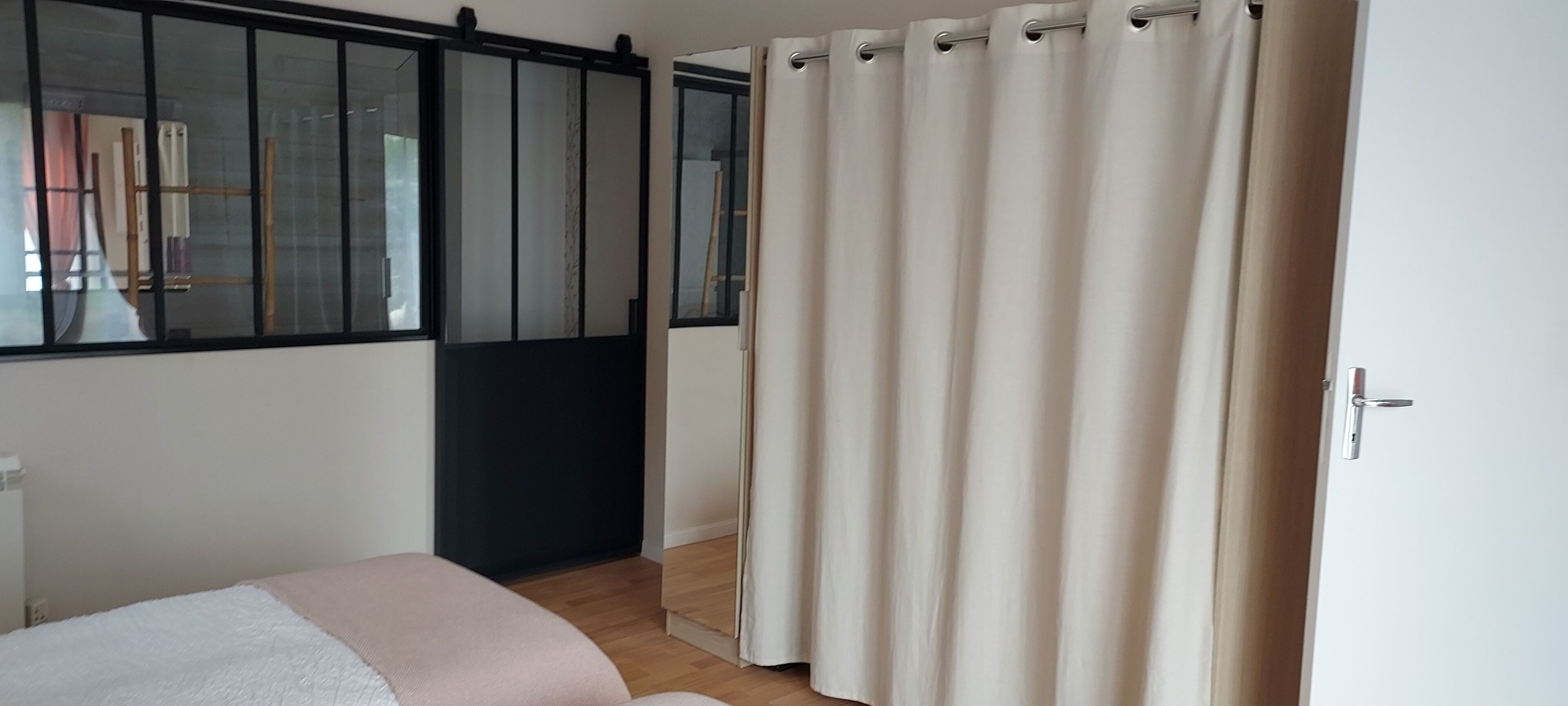 Une chambre avec un lit, une porte coulissante et une fenêtre donnant sur un beau paysage.