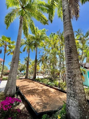 Ein tropisches Resort mit Palmen, einem Sandstrand und einem Pool.