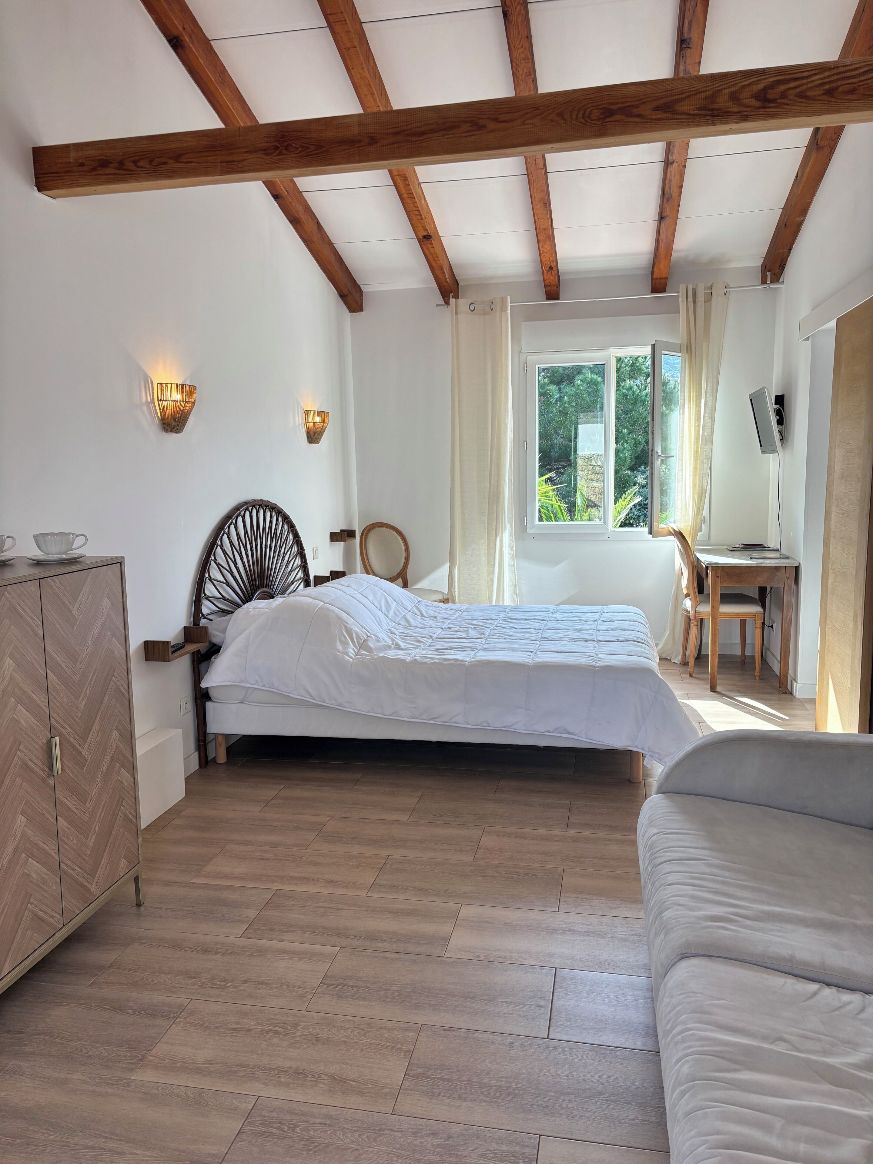 Un dormitorio con cama, escritorio y silla.