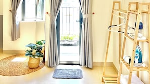 Une pièce donnant sur l’extérieur, une échelle en bois avec des serviettes et un tapis tissé.