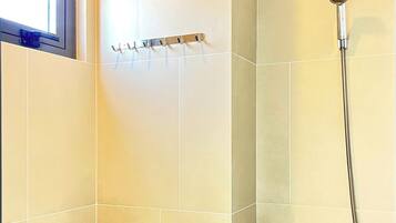 Un baño con inodoro, ducha y ventana.