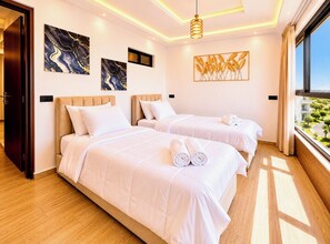 Habitación de hotel con dos camas, detalles de mármol, vista a zonas verdes y un diseño moderno del techo.