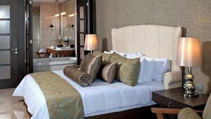 Una habitación de hotel con cama, lámparas de noche, una silla y un espejo.