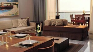 Una sala de estar moderna con un sofá, una mesa de comedor y vista al mar.