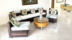 A living room with a sofa set, a coffee table, and a painting on the wall. - Villa with lagoon pool 10 minutes from the center (El Limón)