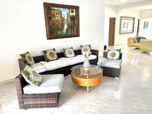 A living room with a sofa set, a coffee table, and a painting on the wall.