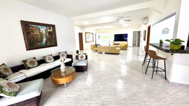 A spacious living area with a sofa set, a coffee table, and a bar area with a plant. - Villa with lagoon pool 10 minutes from the center (El Limón)