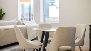 A modern interior with a round table and four chairs, a sofa, and a lamp. - Vintage Moderne – Old MTL Retreat (Montréal)