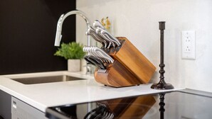 Eine Küche mit modernem Wasserhahn, einem Schneidebrett aus Holz und einer Glasarbeitsplatte.