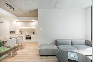 A modern apartment with a kitchen, dining area, and a grey sectional sofa. - Modern Elegant Apartment in Old Montreal (Montreal)