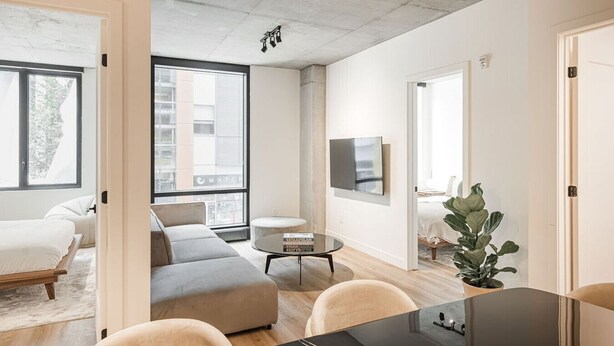 Ein modernes Wohnzimmer mit Sofa, Couchtisch und Fernseher.