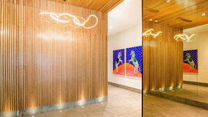Un intérieur moderne avec des murs lambrés, un sol carrelé et des œuvres d’art abstraites accrochées au mur.
