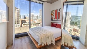 Camera da letto con un grande letto, vista sulla città e design moderno.