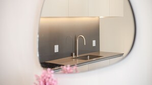 Ett modernt kök med en diskho i rostfritt stål, ett böjt blandare och en minimalistisk design.