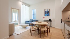Un appartement moderne comprenant un coin repas, un canapé, une table basse et une cuisine.