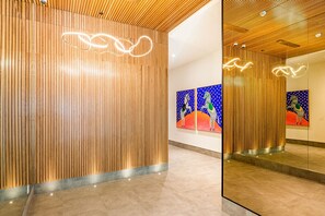 Ein modernes Interieur mit Holzwänden, einem spiegelnden Boden und abstrakter Kunst an den Wänden.