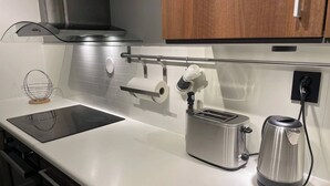 A kitchen with a countertop, a toaster, a kettle, and a paper towel holder. - Renovated Apartment High Standard to City Center, Park (Tromsø)