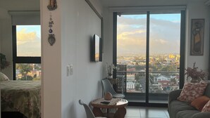 Un área de estar amplia con balcón, una mesa de comedor y un sofá.