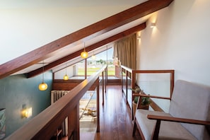 Une pièce de style loft avec un escalier en bois, un canapé et des lampes suspendues.