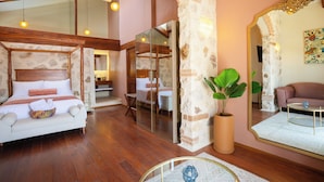 A modern bedroom with a large bed, a sitting area, and a dining space. - Corazante Boutique Hotel (San Andrés Cholula)