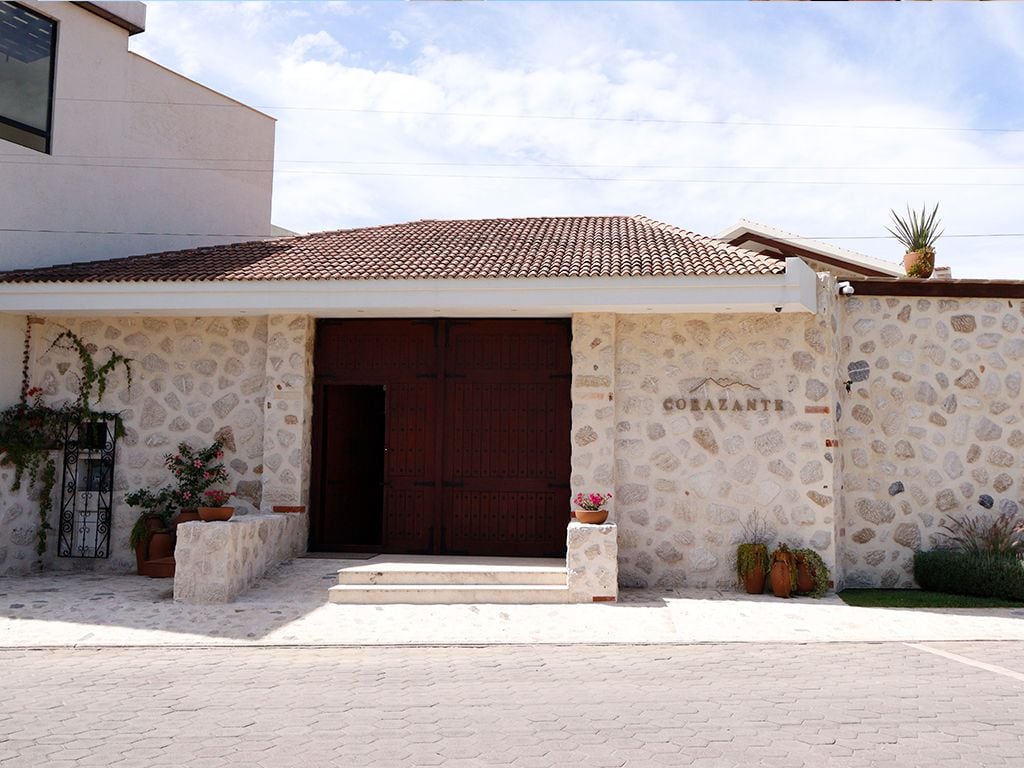 Un edificio con fachada de piedra, una puerta grande de madera y el nombre 'COBAZANT' en la pared.