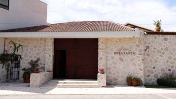 Un edificio con fachada de piedra, una puerta grande de madera y el nombre 'COBAZANT' en la pared.