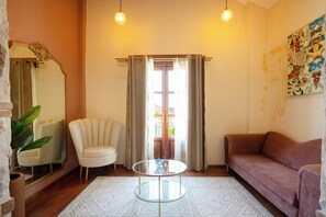 Un salon comprenant un canapé, un fauteuil et une table basse ronde en verre.