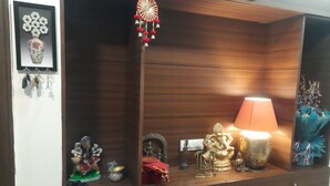 Un mobiletto in legno con un ornamento appeso, un quadro incorniciato e vari oggetti decorativi.