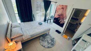 Un dormitorio con cama, escritorio, silla, ventana con cortinas, un póster y un radiador.
