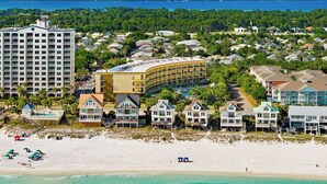 Ein Küstenort mit Strandhäusern, einem großen Hotel und einem Poolbereich.