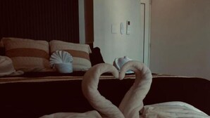 A bed with a wooden headboard, a pillow, and a blanket arranged in a heart shape. - Pelicanos  (Alvarado)