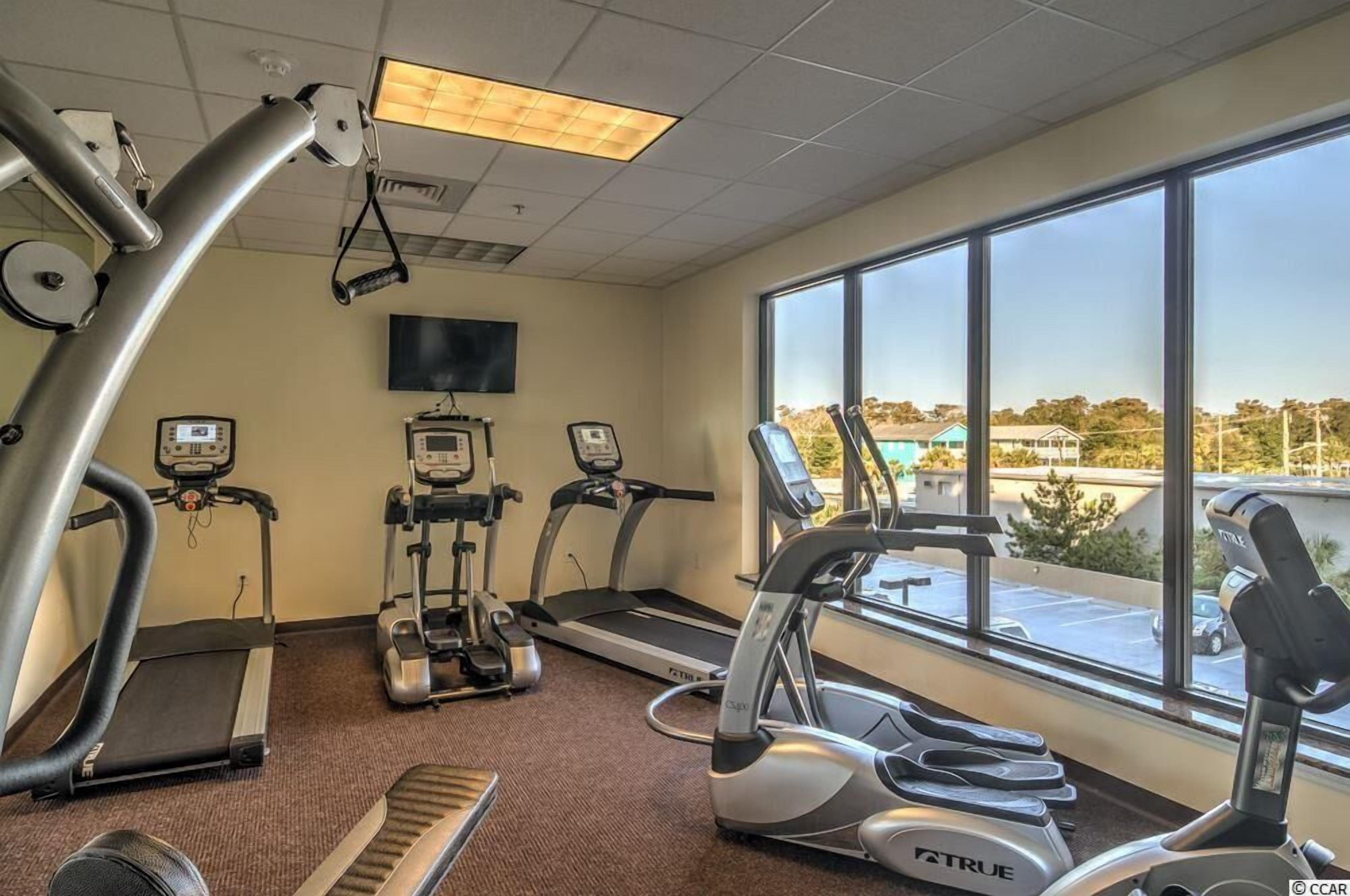 A gym with treadmills, elliptical machines, and a stationary bike.