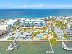 Ein Küstenhotel mit mehreren Gebäuden, einem Schwimmbad und einem Steg.